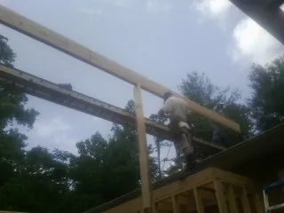 Carpenter setting a ridge beam over a new addition frame — Ice Dam Removal by Roofing Brothers in New Lexington