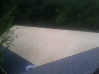 New OSB roof sheathing installed beside an existing shingle roof in New Lexington