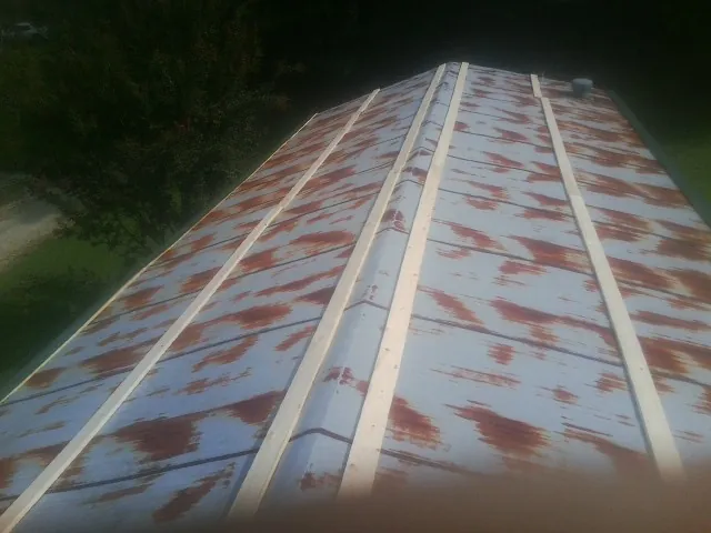 Rusted metal roof panels with new wood purlins before replacement — Storm Damage Roof Repair in New Lexington by Roofing Brothers