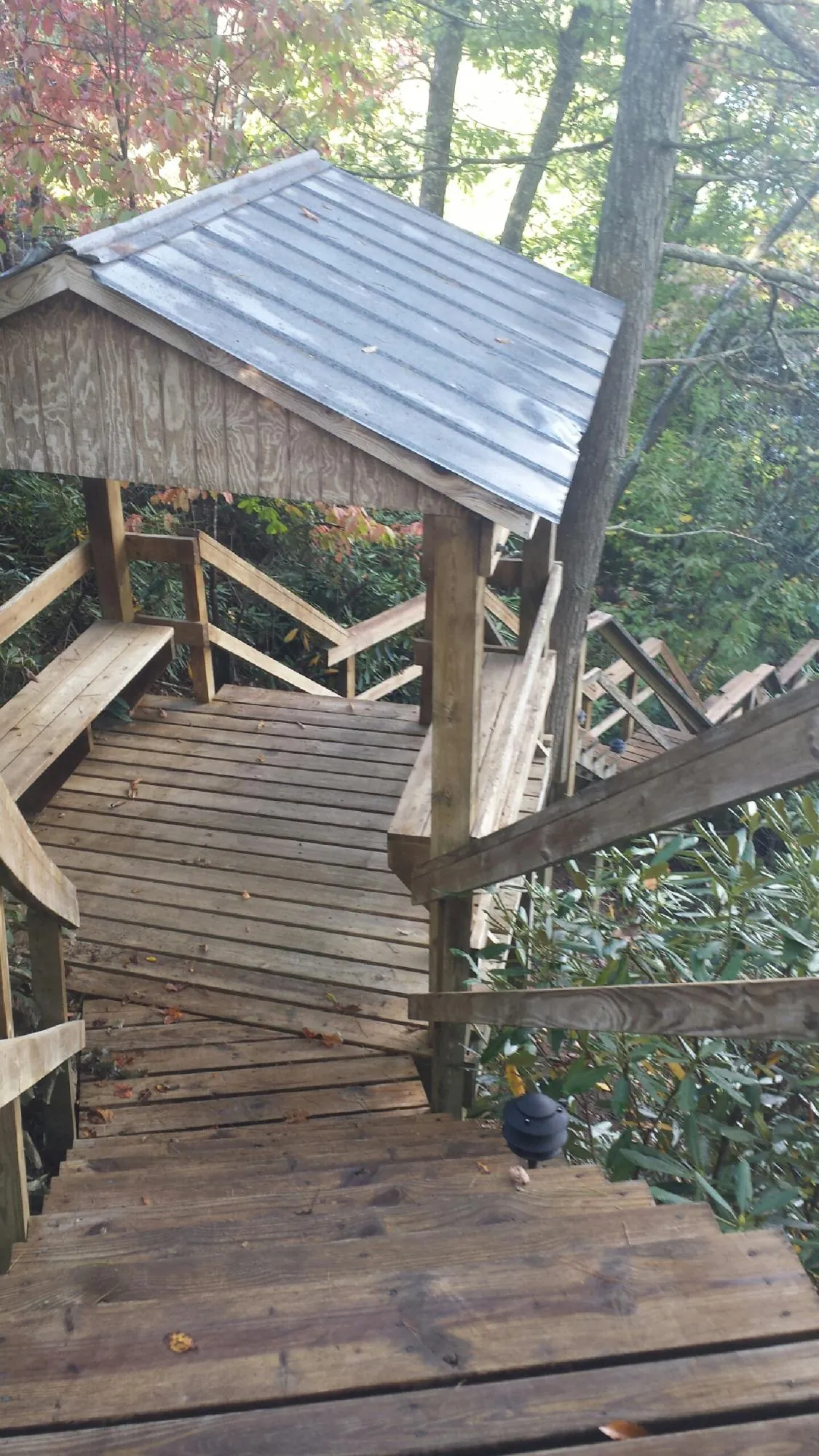 Metal roofed shelter over wooden steps on a wooded walkway — Skylight Repair & Installation work by our crew in New Lexington