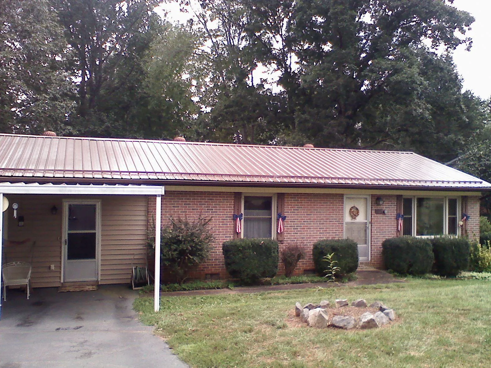 Bronze metal roof and carport on a brick ranch home — Roof Repair work by our crew in New Lexington